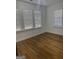 Spacious bedroom featuring hardwood floors and three windows with blinds at 845 Metropolitan Sw Pkwy, Atlanta, GA 30310