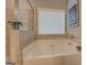 A bright bathroom featuring a soaking tub with neutral tile and natural light at 4128 Pemberton Dr, Covington, GA 30014