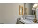 Elegant half bath featuring a granite countertop, decorative mirror, and stylish lighting at 4128 Pemberton Dr, Covington, GA 30014