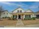 Charming home featuring a covered front porch, black shutters, and well-maintained landscaping at 4128 Pemberton Dr, Covington, GA 30014