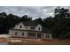 Two-story house with gray brick and white accents, a black roof, and a large driveway at 8795 St Patrick'S Way # 2, Winston, GA 30187