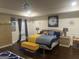 Bedroom with hardwood flooring, elegant chandelier, bench, and a large bed with blue and yellow bedding at 4051 Rotterdam Pass, Hampton, GA 30228