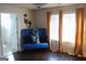 Bedroom featuring hardwood floors, neutral paint, elegant blue seating, curtains, and decorative wall art at 4051 Rotterdam Pass, Hampton, GA 30228