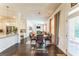 Open dining area with hardwood floors, modern chandelier, and view into the living area with fireplace at 4051 Rotterdam Pass, Hampton, GA 30228
