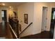 Hallway with dark hardwood floors, wood railing, neutral walls, and doors leading to other rooms at 4051 Rotterdam Pass, Hampton, GA 30228