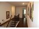 Hallway with dark hardwood floors, wood railing, neutral walls, and interior doors at 4051 Rotterdam Pass, Hampton, GA 30228