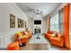 Stylish living room with bright orange sofas, modern decor, and hardwood floors at 4051 Rotterdam Pass, Hampton, GA 30228