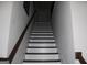 View of the home's stairway with white risers, dark treads, and a wood handrail leading to the next level at 4051 Rotterdam Pass, Hampton, GA 30228