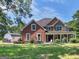 Brick house with stone accents, a large front porch, and landscaping at 10 Toscanno Dr, Covington, GA 30014