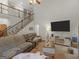 Open living room with high ceilings, hardwood floors, and a large TV at 10 Toscanno Dr, Covington, GA 30014