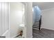 Powder room with pedestal sink and dark wood staircase at 3170 Fareed St, Douglasville, GA 30135