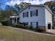 Charming home featuring tan siding, dark shutters, a covered porch, and mature landscaping at 3648 E Melissa Ln, Douglasville, GA 30135