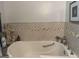 Close-up of a bathtub with tiled walls and nautical decor at 1551 Ferno Nw Dr, Atlanta, GA 30318
