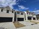 Newly built townhomes with brick facades, black garages, concrete driveways, and bright blue skies at 1935 Westwind Street # 157, Lawrenceville, GA 30043