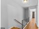 Light-filled stairwell with wood flooring and simple black railing at 121 Arbor Gate, Peachtree City, GA 30269