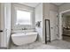 Bathroom with free-standing bathtub and marble-style tile at 35 Oakhurst Trl, Sharpsburg, GA 30277