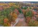 Aerial view of house nestled in wooded area with fall colors at 2949 Hog Mountain Rd, Dacula, GA 30019