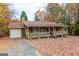 Ranch house with attached garage and porch, surrounded by fall foliage at 2949 Hog Mountain Rd, Dacula, GA 30019