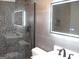 Modern bathroom with pebble tile shower, gray tile, and frameless glass at 4490 Latchwood Dr, Lithonia, GA 30038