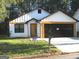 Front view of a charming craftsman style home with a black garage door at 4490 Latchwood Dr, Lithonia, GA 30038