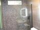 Modern shower with pebble tile surround and frameless glass door at 4490 Latchwood Dr, Lithonia, GA 30038