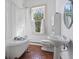 Charming bathroom with clawfoot tub, pedestal sink, and terracotta tile floor at 3115 Pennington Sw St, Covington, GA 30014