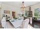 Bright dining room with a white table, tufted chairs, and views of the kitchen at 3115 Pennington Sw St, Covington, GA 30014