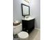 Bathroom with dark vanity, mirror, and updated fixtures at 7665 Antebellum Ln, Riverdale, GA 30274