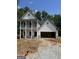 Two-story home featuring a two-car garage and a charming porch at 115 Yancey Rd, Covington, GA 30014