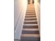 Indoor stairs with carpeted steps and neutral walls at 6258 Ellenwood Dr, Rex, GA 30273