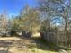 Partially fenced backyard with trees and grassy areas at 3449 Highway 138 Ne, Conyers, GA 30013