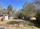 Large backyard with trees, a wooden fence, and shed at 3449 Highway 138 Ne, Conyers, GA 30013