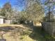 Backyard with trees and a partially damaged fence at 3449 Highway 138 Ne, Conyers, GA 30013