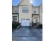 Tan two-story townhome with white garage door and landscaping at 6022 Centennial Run, Atlanta, GA 30349