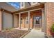 Inviting covered front porch with brick columns and a decorative front door at 417 Creekside Park, Covington, GA 30014