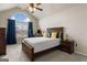 Bright bedroom with large window, wood bed frame and ceiling fan at 801 Carnegie Ct, Locust Grove, GA 30248