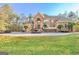 Grand brick home with circular driveway and lush lawn at 180 Wesley Forest Dr, Fayetteville, GA 30214