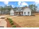 Charming white farmhouse with a covered porch and well-manicured lawn, perfect for Gathering living at 0 Pinegate Way, Sharpsburg, GA 30277