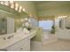 Spa-like bathroom with double vanities and a step-up soaking tub at 3443 Pinemont Dr, Douglasville, GA 30135