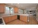 L-shaped kitchen with light wood cabinets, gas cooktop, and a view of the living room at 3443 Pinemont Dr, Douglasville, GA 30135