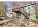 Rear view of green house showing deck, stairs, and fenced yard at 1638 River Trc, Auburn, GA 30011