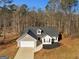 Aerial view of a charming ranch home on a wooded lot at 135 Kimbell Farm Dr, Locust Grove, GA 30248