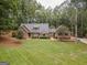 Brick house with gray roof, large yard, and driveway at 107 Rolling Green, Peachtree City, GA 30269