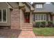 Red front door, brick steps, and landscaping at 107 Rolling Green, Peachtree City, GA 30269