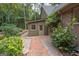 Landscaped side yard with brick pathway leading to a detached storage building at 107 Rolling Green, Peachtree City, GA 30269