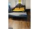 Image of an empty bedroom with laminated wood flooring and partially assembled furniture at 1344 Lynford Sw Dr, Atlanta, GA 30310