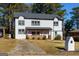 Two-story white house with gray roof, wooden porch, and driveway at 2036 E Camellia Dr, Decatur, GA 30032