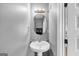 Small bathroom with pedestal sink and oval mirror at 11945 Lovejoy Crossing Way, Hampton, GA 30228