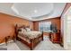 Cozy bedroom with a wooden bed frame and TV stand at 11945 Lovejoy Crossing Way, Hampton, GA 30228