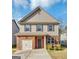 Two-story house with brick and beige siding, a two-car garage, and a well-manicured lawn at 11945 Lovejoy Crossing Way, Hampton, GA 30228